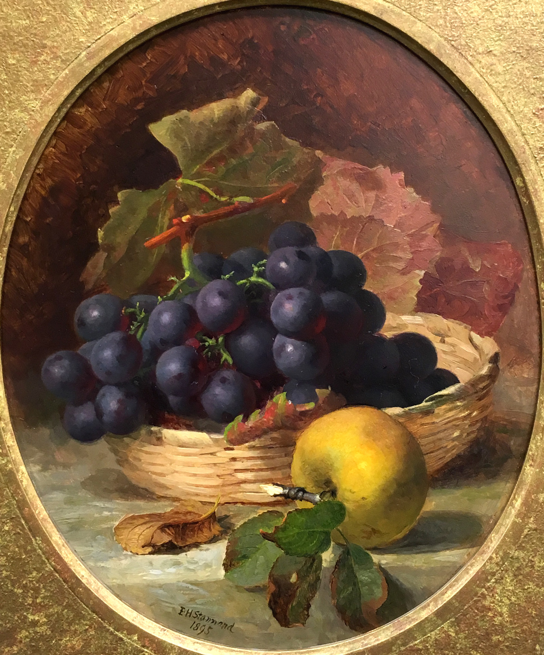 A basket of black grapes and an apple; Raspberries and peaches on a table